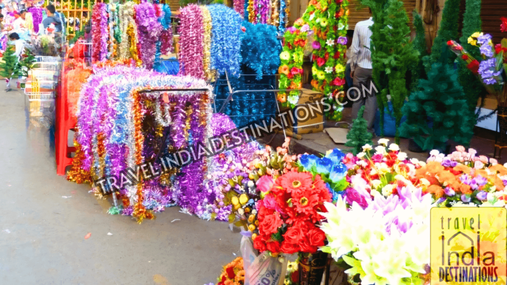 A picture of street stalls in Crawford Market selling artificial flowers and tinsel garlands for decoration. 