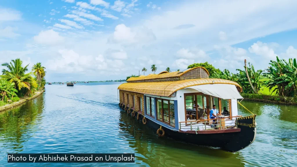 A houseboat making way through the backwaters of Kerala in Alleppey with clear blue sky works well when paired with Kochi.