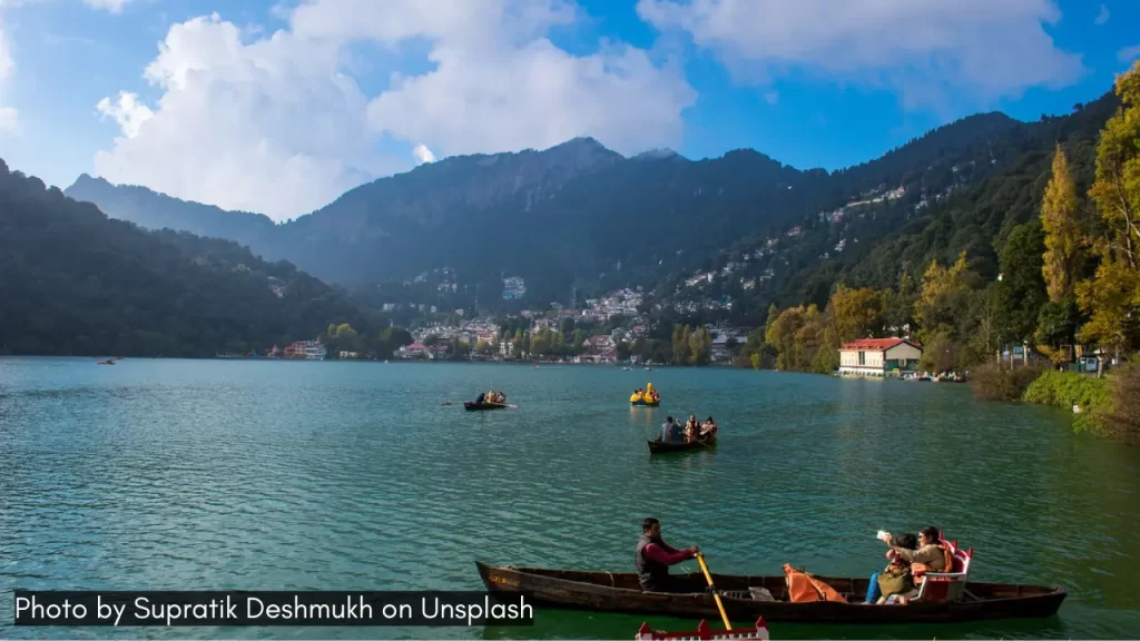 A scenic shot of people boating in Nainital Lake, one of the best places for minimoon in April in India. 