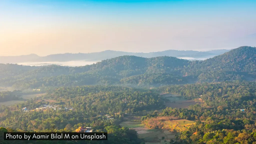 A panoramic shot of Coorg hills with summer sunshine, one of the best places for minimoon in April in India.