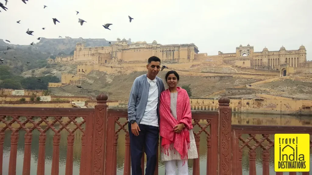 A couple standing before Amber (Amer) Fort during winter season, one of the best places to visit in Jaipur.