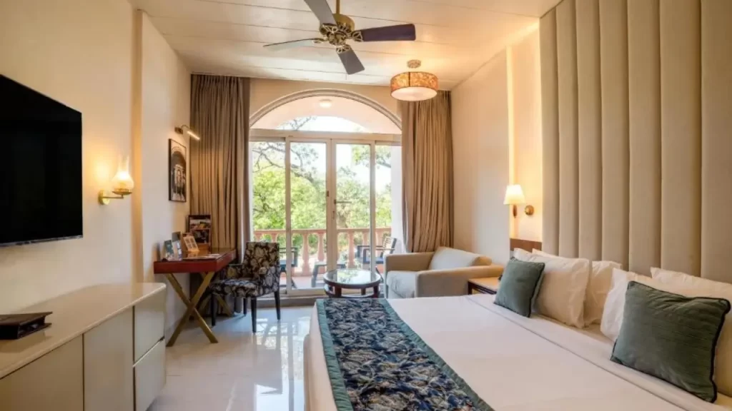 Modern guest room at Evershine Resort & Spa in Mahabaleshwar featuring plush bedding, ambient lighting, and garden-facing balcony