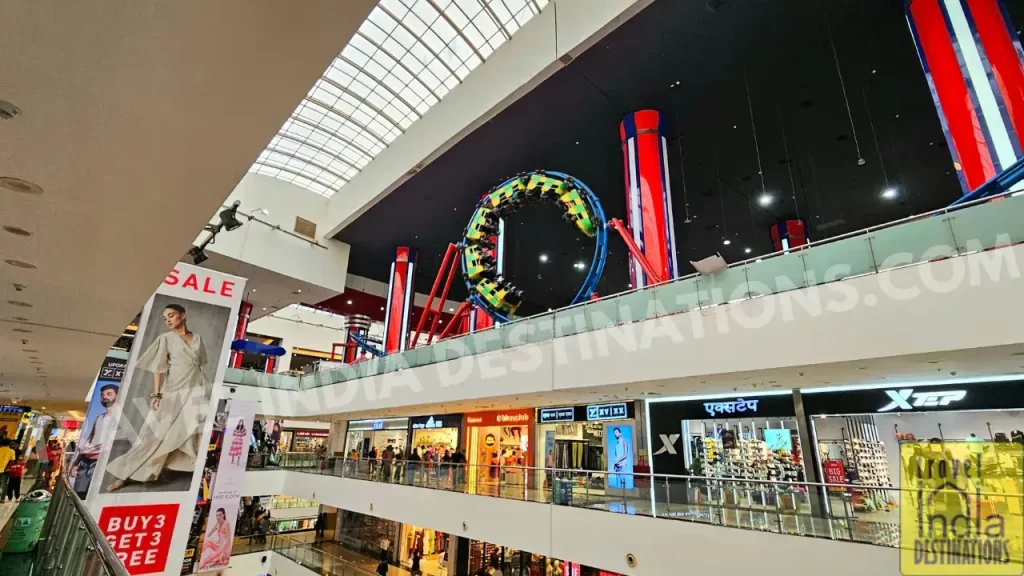 Indoor roller coaster at Infinity Mall 2 completing a 360-degree loop on the top floor near the food court.
