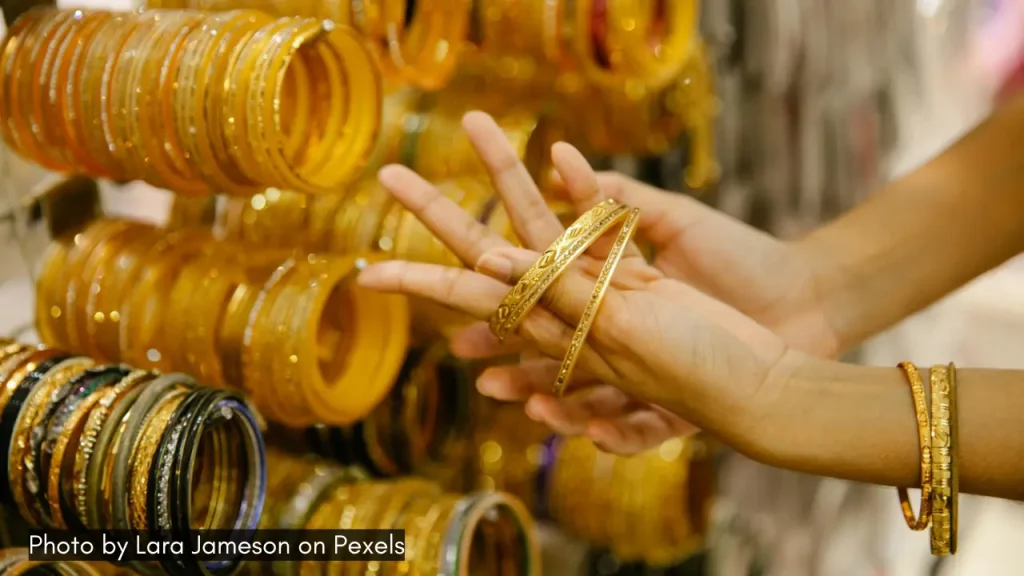 A close up shot of a hand wearing golden bangles at one of the shopping markets in Jaipur.