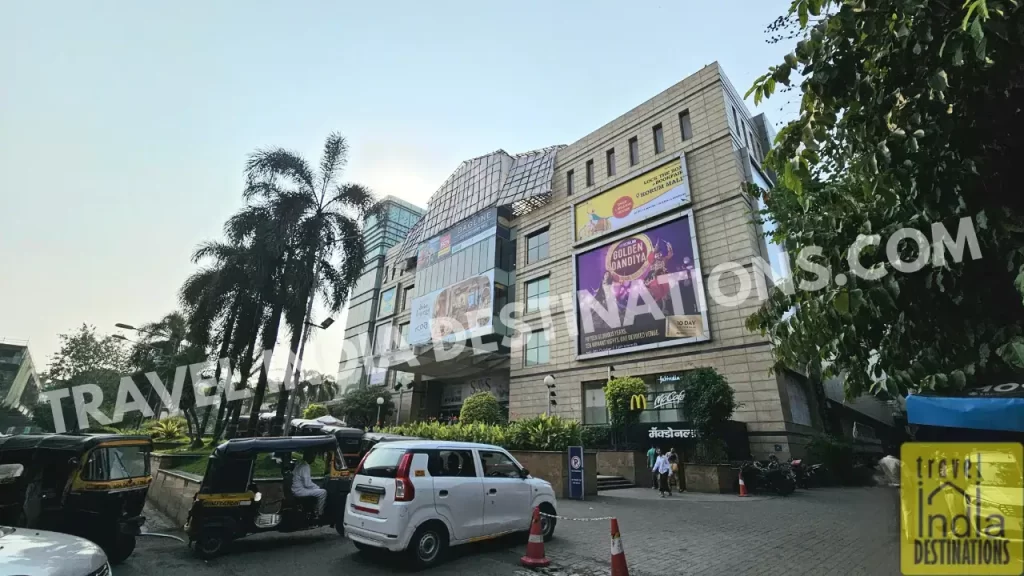 Exterior view of Korum Mall Thane with vehicles entering the premises and signage visible at the entrance
