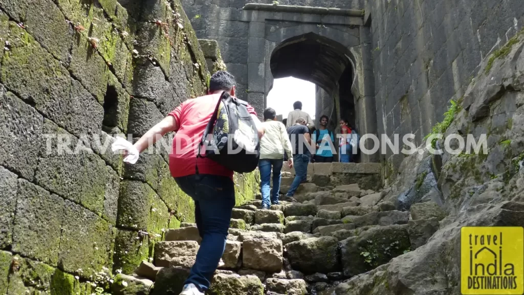 Trekkers approaching Hanuman Darwaza at the Lohagad Fort while trekking during monsoon season.