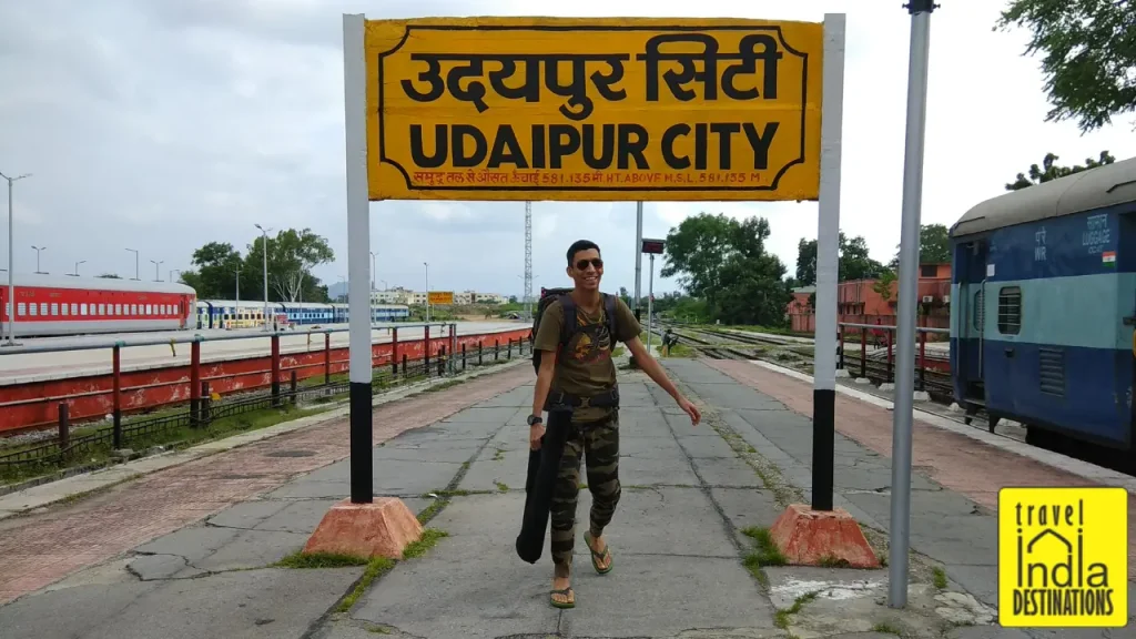 A picture of a man standing at Udaipur Railway station excited for the trip ahead.