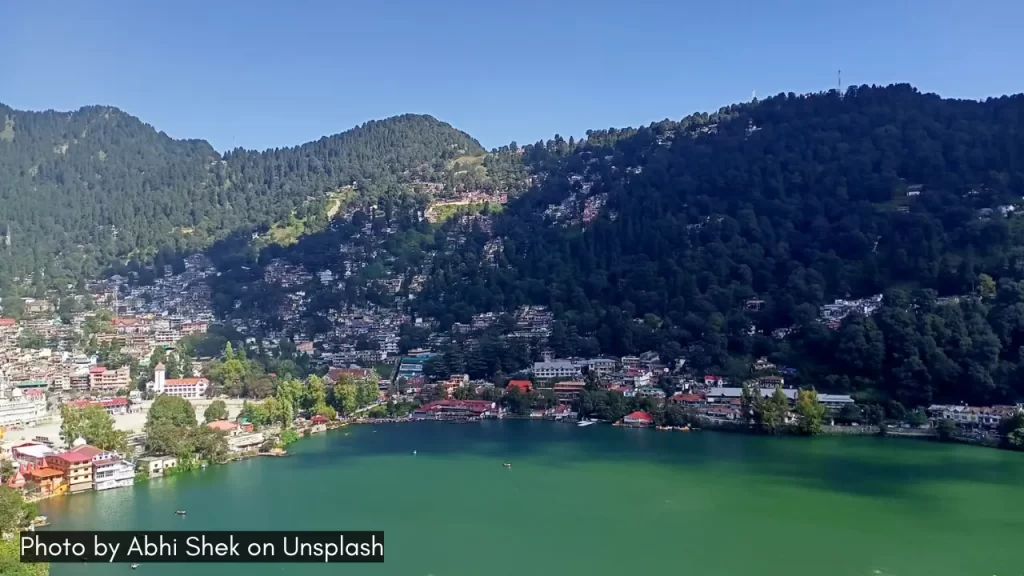 A panoramic view of Lake Naini and oak trees around the hills in Nainital, one of the best honeymoon towns in India in April.
