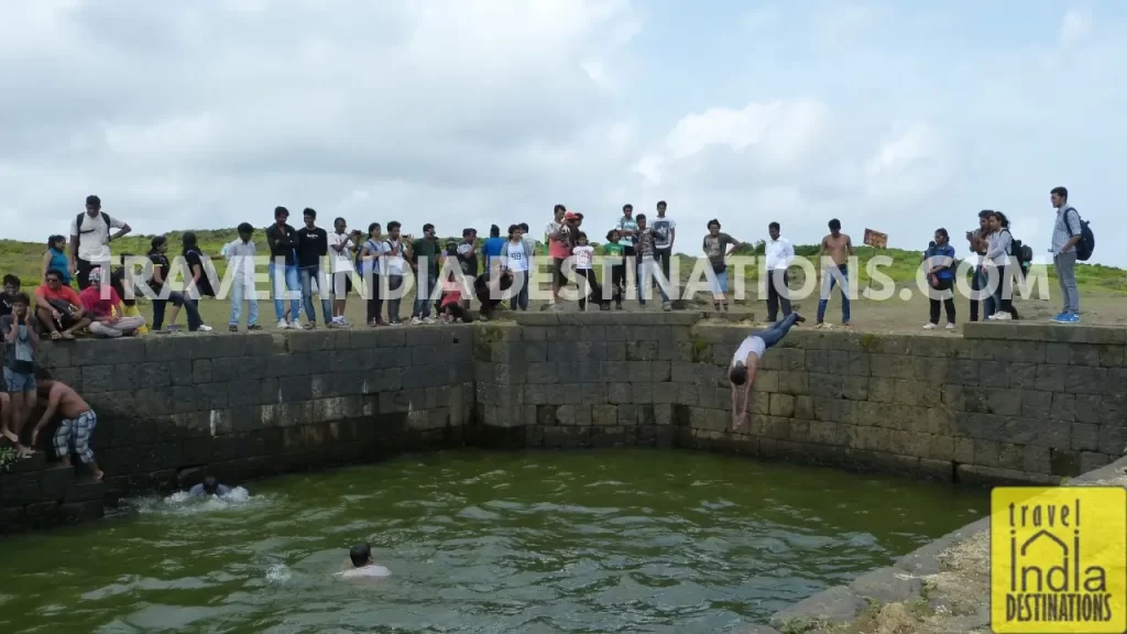 A group of people swimming in one of the wells at the Lohagad Fort refreshing themselves. 