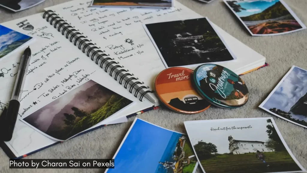 A picture of book, pen and images of various places for planning for honeymoon in India.