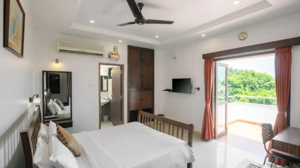 A shot of Deluxe Room with a balcony at Pondicherry Executive Inn, one of the best hotels close to the beach.