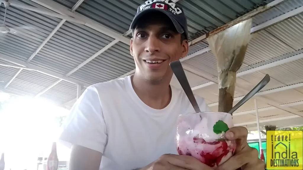 A man enjoying a strawberry milkshake at Mapro Garden one of the best places to visit in Lonavala