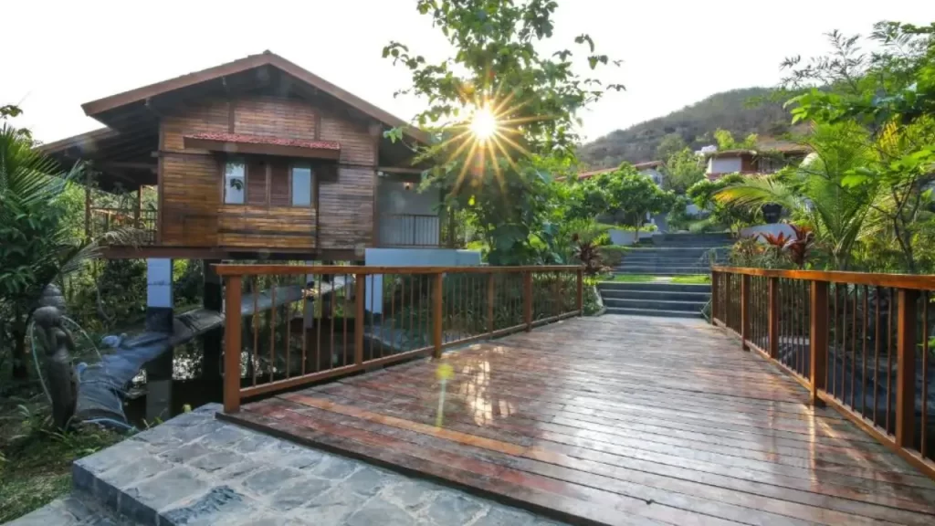 Wooden bridge and cottages at sunrise at Toyam by Orchid Hotels one of the lovely hotels near ghats in Maharashtra