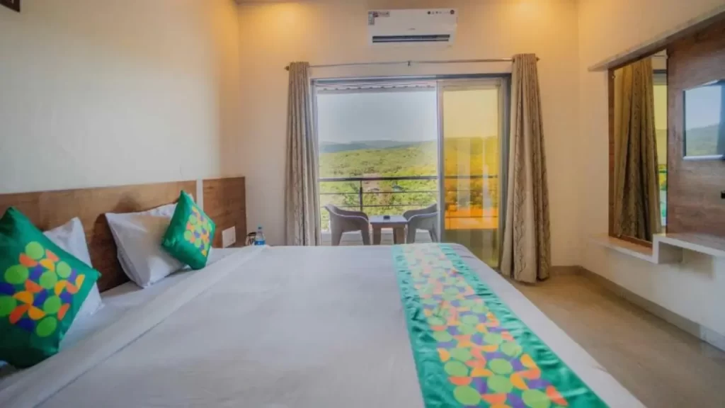 Room at Treebo Venna Hill with bed, AC, and balcony overlooking Mahabaleshwar landscape